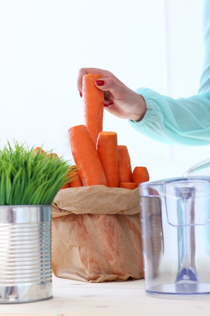 Beautiful girl making carrot juice