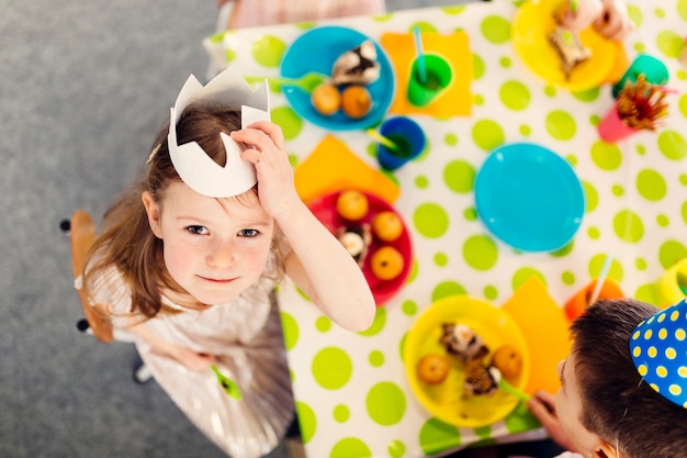 Free photo beautiful girl in paper crown looking at camera