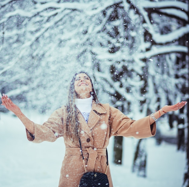 The beautiful girl playing with snow