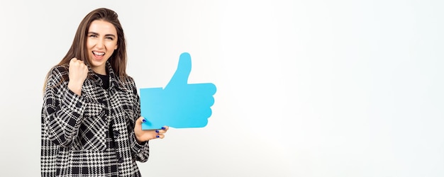 A beautiful girl poses in the background of a white studio holding an advertising banner