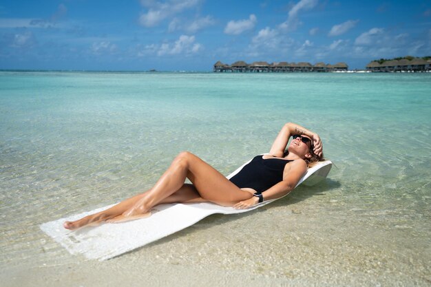 Beautiful girl posing against the backdrop of the blue ocean Maldives