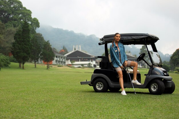 Красивая девушка позирует на поле для гольфа