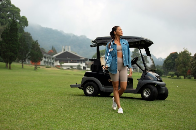 Красивая девушка позирует на поле для гольфа