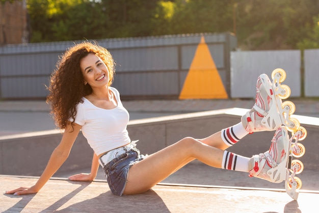 무료 사진 rollerblades를 착용하는 동안 포즈를 취하는 아름 다운 소녀