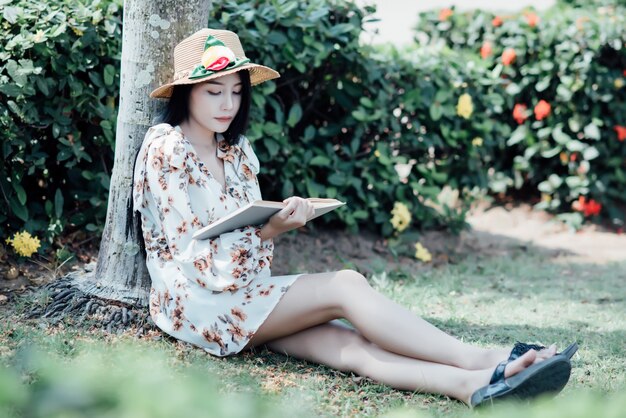 beautiful girl reading book at park in summer sun light
