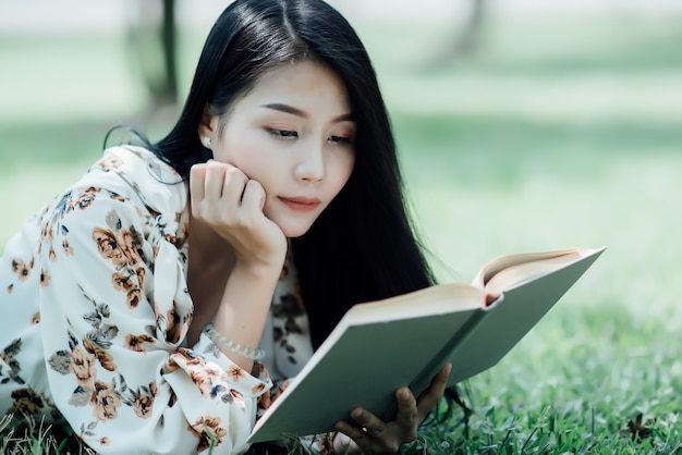 beautiful girl reading book at park in summer sun light