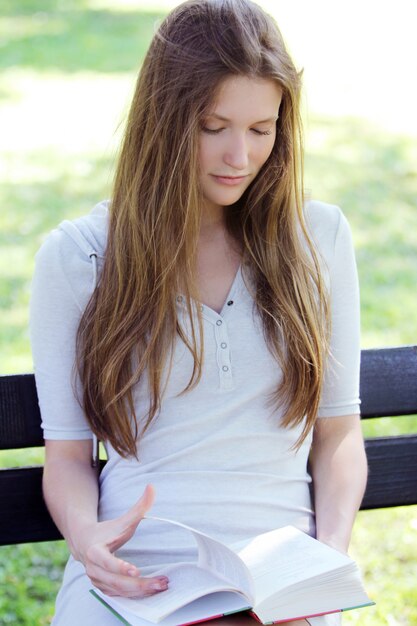 Beautiful girl reading book in the park