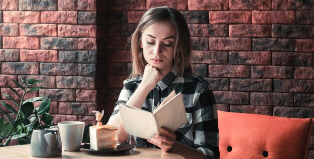 美しい少女はカフェで本を読みます