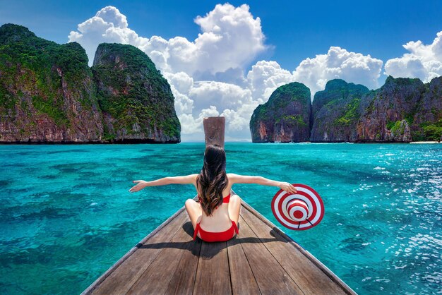 Красивая девушка в красном бикини на лодке на острове Ко-Пхи-Пхи, Таиланд