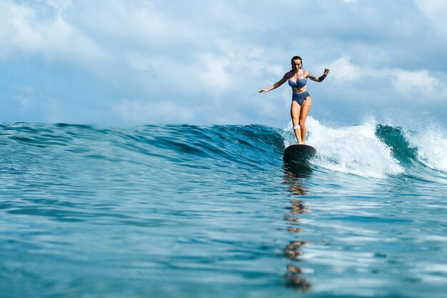 beautiful girl riding on a surf board on the waves