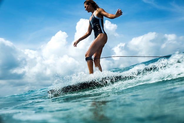 beautiful girl riding on a surf board on the waves