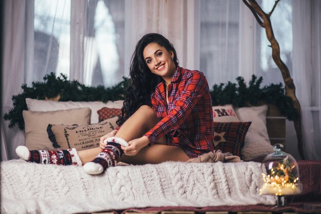 The beautiful girl sits on the bed