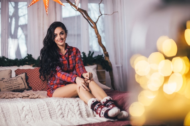 The beautiful girl sits on the bed