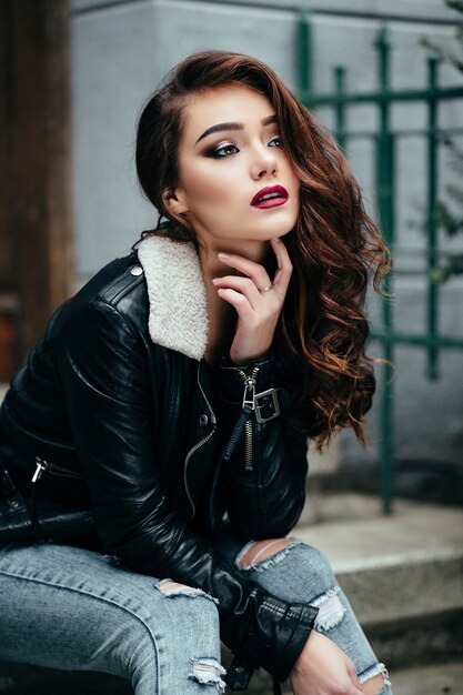 The beautiful girl sits on the stairs