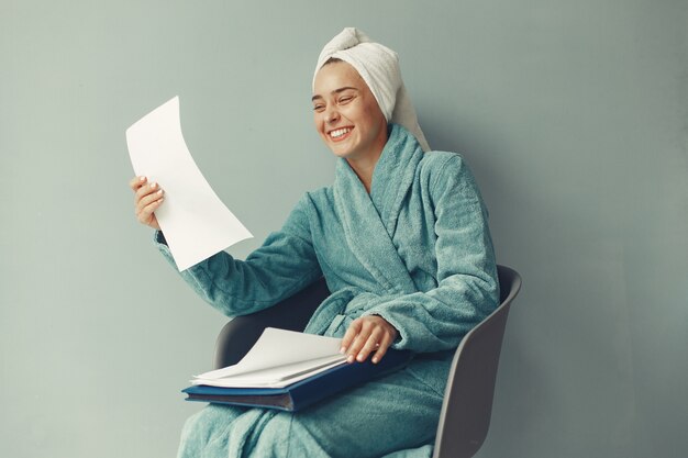 Beautiful girl sitting  in a blue bathrobe