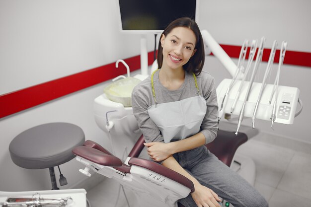 Красивая девушка сидит в кабинете стоматолога