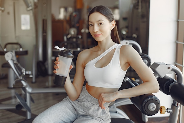 A beautiful girl sitting with water in a gym
