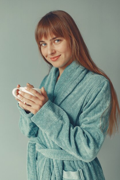 Beautiful girl standing  in a blue bathrobe