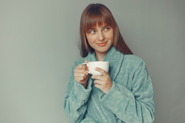 Free photo beautiful girl standing  in a blue bathrobe