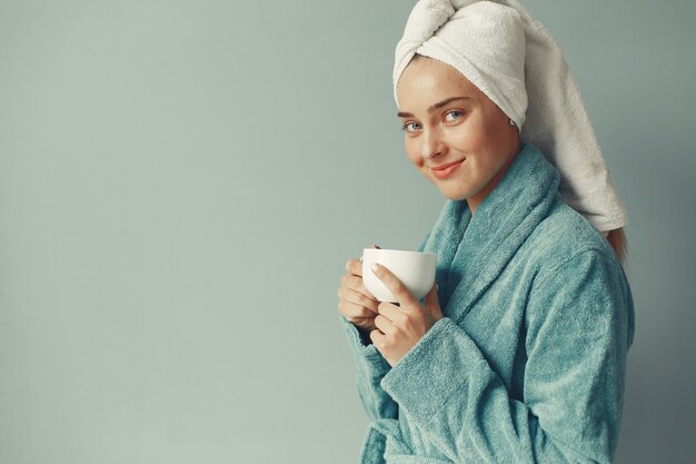 Beautiful girl standing  in a blue bathrobe