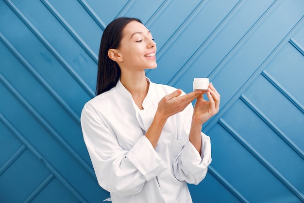 Beautiful girl standing in a studio with cream