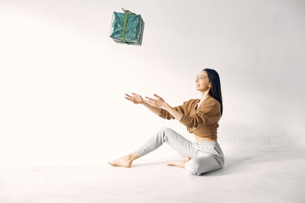 Beautiful girl standing in a studio with presents