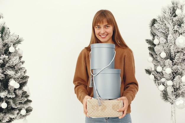 Beautiful girl standing in a studio with presents