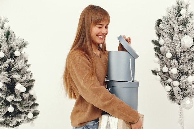 Bella ragazza in piedi in uno studio con regali