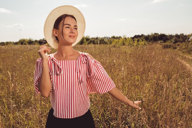 Foto gratuita bella ragazza si trova in un campo in estate