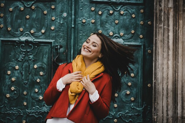 The beautiful girl stands near ancient door