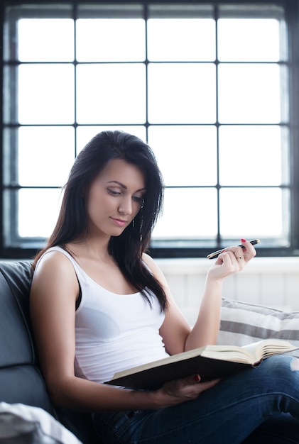 Красивая девушка учится с книгой
