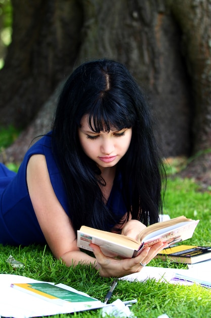 Bella ragazza che studia nel parco