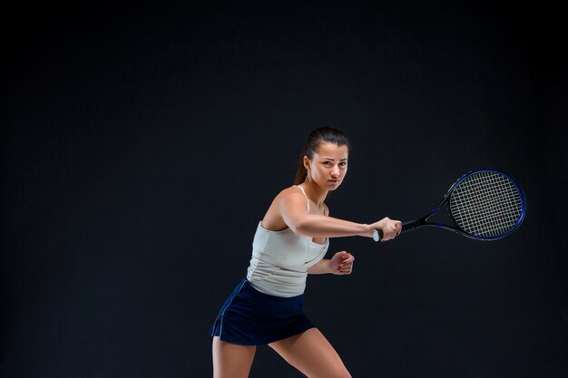 beautiful girl tennis player with a racket on dark background