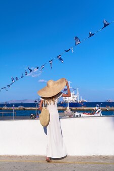 スペツェスマリーナ港ギリシャに立って海を見ている美しい少女観光客 Premium写真