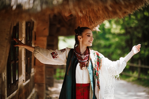 Красивая девушка в традиционном украинском платье танцует и улыбается