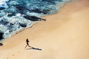 Бесплатное фото Красивая девушка гуляет по дикому пляжу. потрясающий вид сверху.