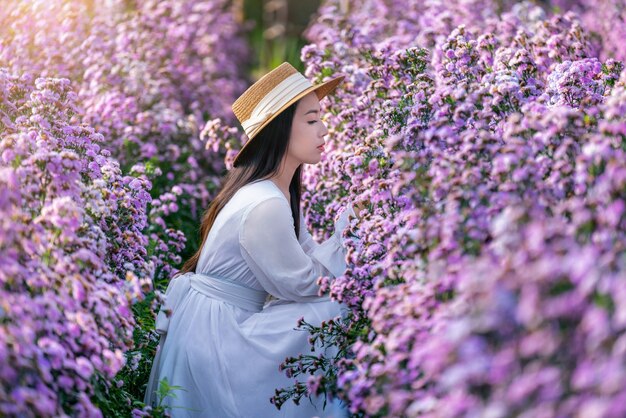 마가렛 꽃 필드에 앉아 하얀 드레스를 입고 아름 다운 소녀