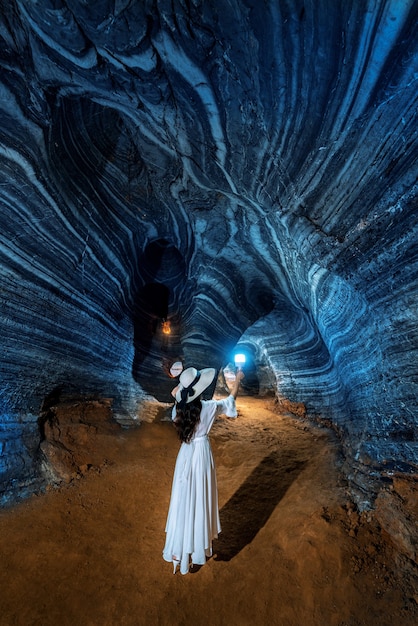Красивая девушка в белом платье гуляет в голубой пещере, Таиланд