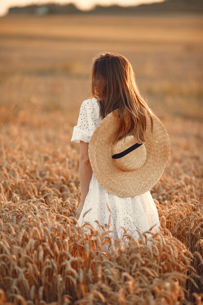 하얀 드레스를 입고 아름 다운 소녀입니다. 가 필드에 여자입니다. 밀짚 모자 아가씨.