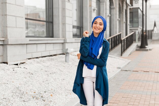 Красивая девушка с хиджабом, улыбаясь на открытом воздухе