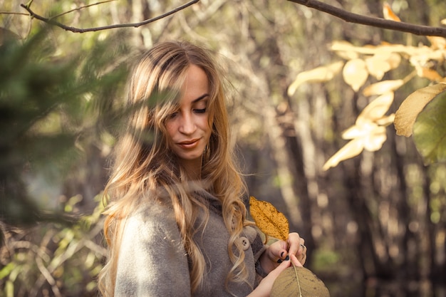 秋の森、秋のシーズンコンセプトで長い髪の美しい少女