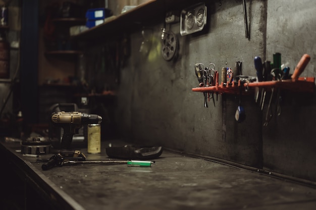 beautiful girl with long hair in the garage repairing a motorcycle