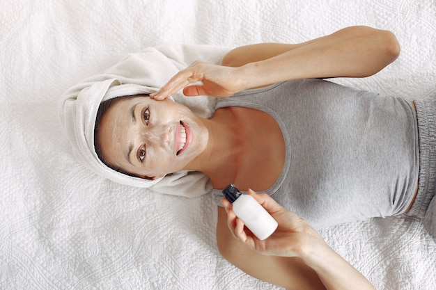 Beautiful girl with a towel using a beauty product