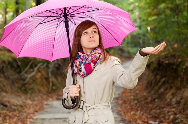 雨をチェック傘を持つ美しい少女