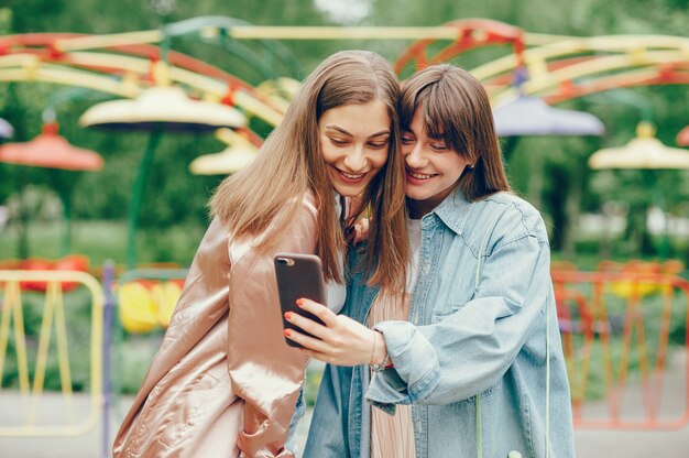 Beautiful girlfriends walking in the park and doing a photo.