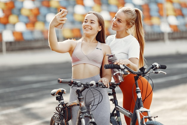 スタジアムの美しい女の子。スポーツウェアのスポーツの女の子。自転車を持っている人。