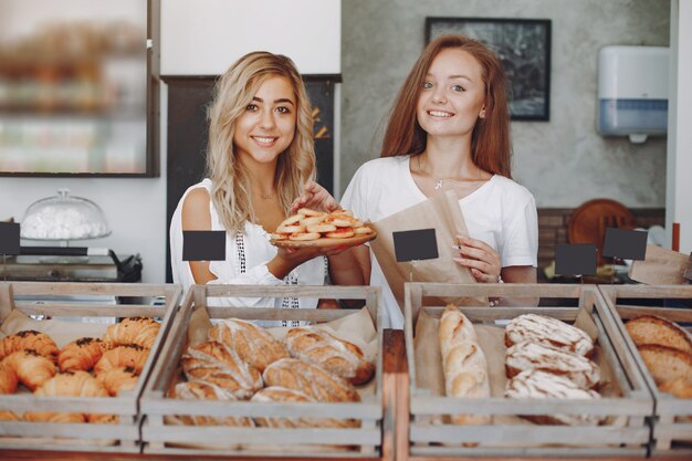 Красивые девушки покупают булочки в пекарне