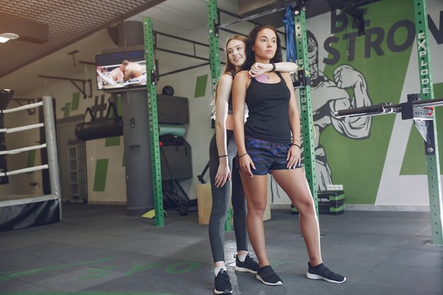 Beautiful girls in a gym. Sports ladies in a sportswear. Friends training