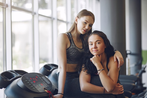 Beautiful girls in a gym. Sports ladies in a sportswear. Friends training