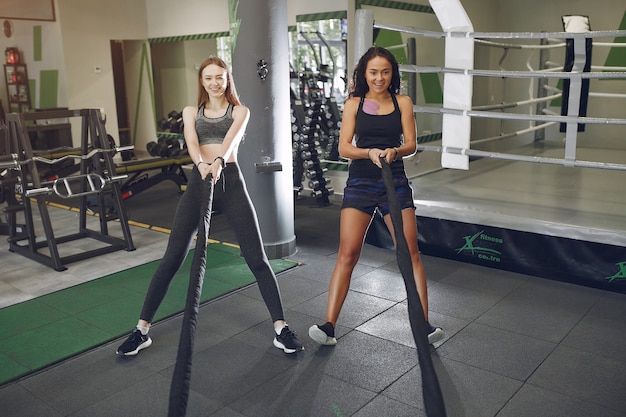 Beautiful girls in a gym. Sports ladies in a sportswear. Friends training